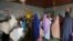 FILE - FILE - Women gather at a clinic to have their children vaccinated in Niamey, Niger, Aug. 21, 2023. Families in Niger say they are struggling in the wake of economic sanctions imposed after a military coup. 