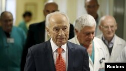 FILE - Former Israeli President Shimon Peres (C) arrives to deliver a statement to the media as he is discharged from a hospital near Tel Aviv, Jan. 19, 2016, his first of two hospitalizations this month. 