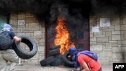 Manifestantes que protestaban contra las reformas gubernamentales arrojaron neumáticos a la entrada de la embajada estadounidense en Tegucigalpa.