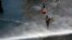 Archivo - Un manifestante ondea una bandera chilena mientras recibe el impacto de un cañon de agua, en Santiago, Chile, el 31 de octubre de 2019.