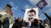 FILE - Followers of jailed Kurdish militant leader Abdullah Ocalan hold up a poster of him in Diyarbakir, Turkey, Feb. 27, 2025. 