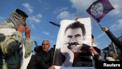 FILE - A demonstrator holds a picture of jailed Kurdish militant leader Abdullah Ocalan during a rally in Diyarbakir, Turkey, Feb. 27, 2025. The Peoples' Equality and Democracy Party has announced a new roadmap to peace following Ocalan's call for his group to disarm. 