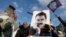 FILE - A demonstrator holds a picture of jailed Kurdish militant leader Abdullah Ocalan during a rally in Diyarbakir, Turkey, Feb. 27, 2025. The Peoples' Equality and Democracy Party has announced a new roadmap to peace following Ocalan's call for his group to disarm.