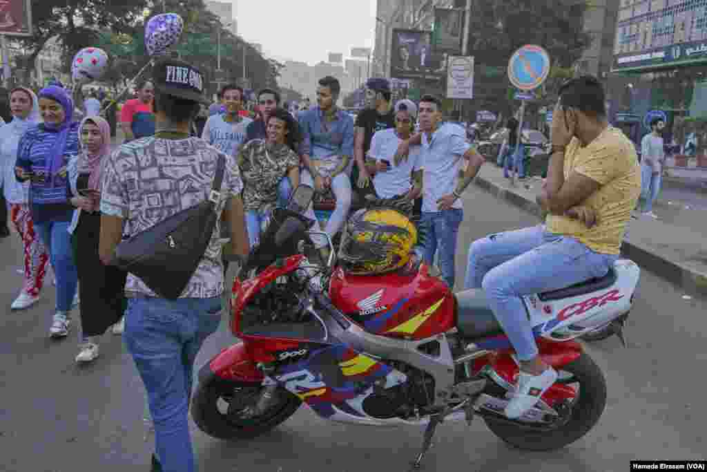 A group of young men joke loudly as three girls pass by during Eid Al-Fitr in Cairo, June 15, 2018.