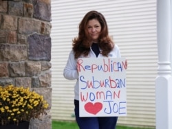 Marygrace Vadala holds a political sign in support of now-President Joe Biden outside her home in Archbald, Pennsylvania, October 28, 2020.