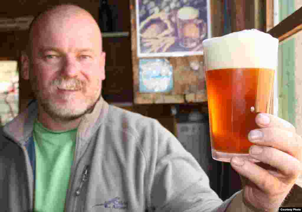 Dirk van Tonder of South Africa admires a freshly poured &lsquo;African pale ale&rsquo; that he brewed using a hop so new it is only known as the J-17-63 hop. (VOA/Darren Taylor)