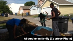 Zacharia Yusuf Abdurahman, right, does volunteer work for Habitat for Humanity in northern Minneapolis as a teenager.