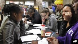 Jóvenes llenan solicitudes de empleo en Pittsburgh, Pennsylvania.