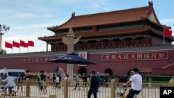 Una persona de seguridad vigila a los residentes que pasan frente a la Puerta de Tiananmen en Beijing, el 4 de junio de 2023. 