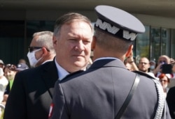 US Secretary of State Mike Pompeo talks to an officer at Pilsudski square in Warsaw, Poland, before ceremonies commemorating the 100th anniversary of the Battle of Warsaw, Aug. 15, 2020.