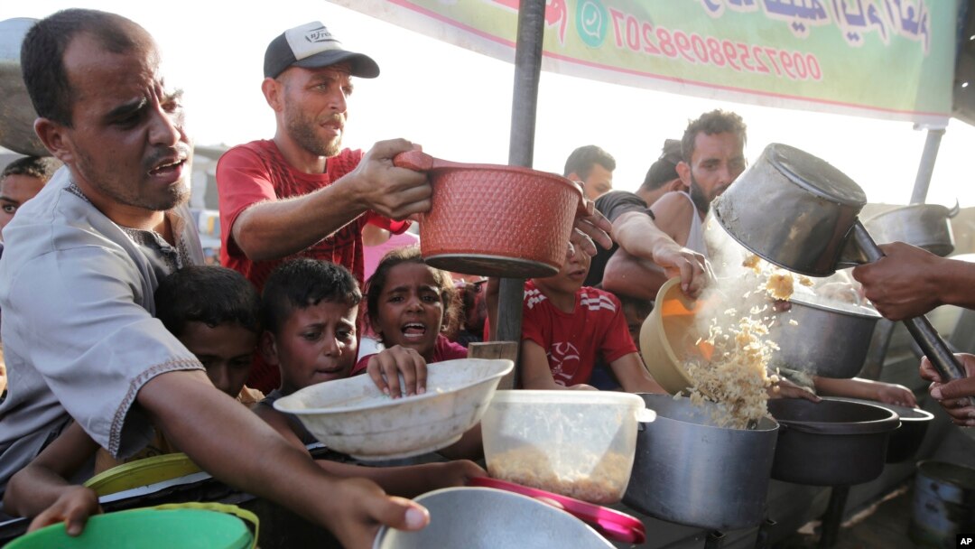 Warga Palestina antre untuk menerima bantuan makanan, sehari menjelang hari raya Iduladha di Khan Younis, Jalur Gaza. 
