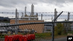 FILE - The MarkWest Bluestone Gas Processing Plant is visible behind the roadside fencing in Evans City, Pa., Oct. 17, 2019.