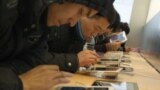 Customers test out Apple iPads in an Apple Store in downtown Shanghai, February 29, 2012.