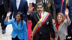 FILE - Venezuela's President Nicolas Maduro, then Constituent National Assembly President Delcy Rodriguez, left, and first lady Cilia Flores, wave as they arrive to the National Assembly, in Caracas, Venezuela, May 24, 2018. The Trump administration slapped financial sanctions Tuesday, Sept. 25, 2018, on four members of Maduro’s inner circle, including his wife, and Rodriguez who is now the nation’s vice president, on allegations of corruption.