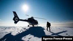 Researcher Ninis Rosqvist walks to the helicopter after visiting the peak of the southern summit of Kebnekaise in northern Sweden to take GPS measurements on the mountain’s height, Aug. 26, 2021.