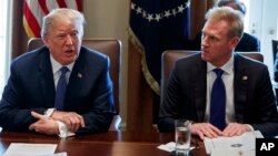 FILE - In this April 9, 2018, photo, Deputy Secretary of Defense Patrick Shanahan, right, listen as President Donald Trump speaks during a cabinet meeting at the White House, in Washington.