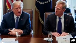 FILE - In this April 9, 2018 photo, Deputy Secretary of Defense Patrick Shanahan, right, listen as President Donald Trump speaks during a cabinet meeting at the White House, in Washington.