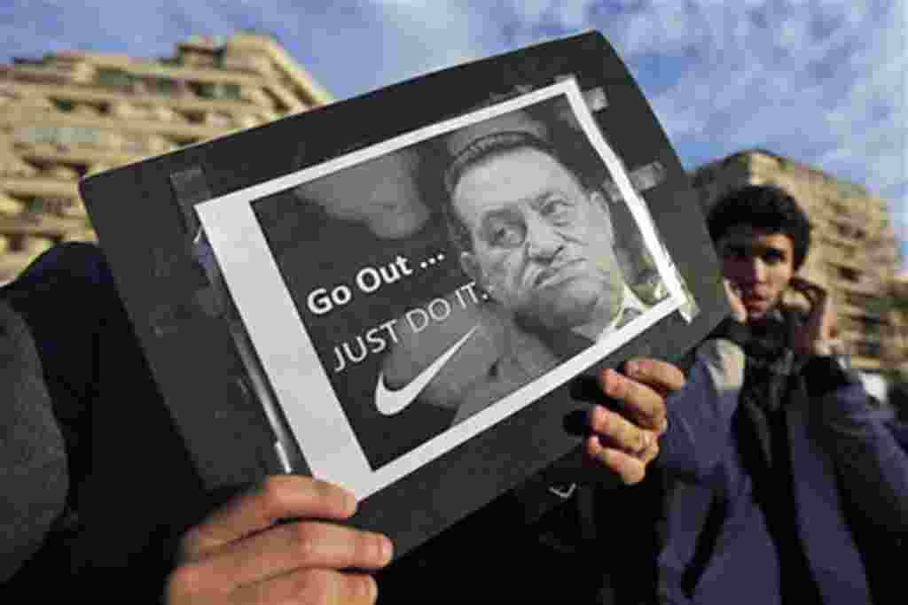 A protester holds a placard showing Egyptian President Hosni Mubarak and reading "Go out... Just do it" at the continuing anti-government demonstration in Tahrir Square in downtown Cairo, Feb 10 2011