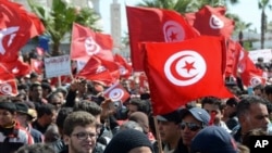 Protestors gather during an anti-extremism march, in Tunis, Sunday, March 29, 2015. Tens of thousands of Tunisians from across the political spectrum marched through the capital Sunday to denounce extremist violence after a deadly museum attack on foreign