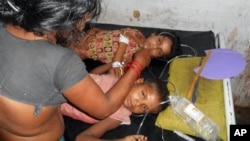 Schoolchildren treated after eating a free meal at a primary school in Chhapra district, eastern Indian state of Bihar, July 16, 2013.