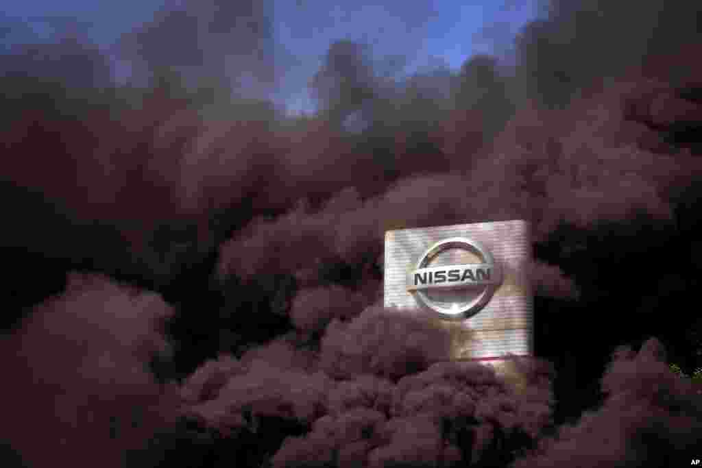 Smoke rises over the Nissan factory as workers burn tires during a protest in Barcelona, Spain. Japanese carmaker Nissan Motor Co. is closing its manufacturing plants in northeastern Catalonia, resulting in the loss of some 3,000 jobs.