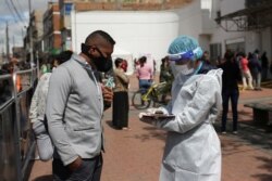 An employee of the Ministry of Health talks to a man who will undergo a rapid test for the coronavirus disease (COVID-19), in Bogota, Colombia, July 1, 2020.