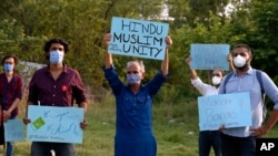 FILE - Members of a civil society group hold a demonstration demanding the government allow the construction of a Hindu temple, in Islamabad, Pakistan, July 8, 2020.