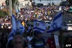 Keluarga dan pendukung sandera Israel yang ditawan di Jalur Gaza sejak serangan 7 Oktober oleh militan Hamas Palestina, mengibarkan bendera dan plakat saat mereka berunjuk rasa di Yerusalem pada 1 September 2024. (Foto: AFP)