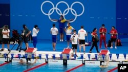 FILE: Athletes gather at the pool during a swimming training session at the Tokyo Aquatics Centre at the 2020 Summer Olympics, Wednesday, July 21, 2021, in Tokyo, Japan. (AP Photo/Martin Meissner)