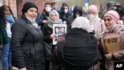 Syrian women stay together after the verdict in front of the court in Koblenz, Germany, Jan. 13, 2022. A German court has convicted a former Syrian secret police officer of crimes against humanity for overseeing the abuse of detainees at a jail near Damascus a decade ago. 
