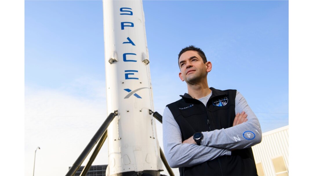 Jared Isaacman, pendiri dan CEO Shift4 Payments, berdiri di depan potret roket Falcon 9 tahap pertama di Space Exploration Technologies Corp. (SpaceX), 2 Februari 2021. (Patrick T. FALLON / AFP)