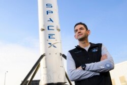 Jared Isaacman, pendiri dan CEO Shift4 Payments, berdiri di depan potret roket Falcon 9 tahap pertama di Space Exploration Technologies Corp. (SpaceX), 2 Februari 2021. (Patrick T. FALLON / AFP)