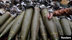 Ukrainian service members fire a shell from an M777 Howitzer at a front line in Donetsk Region