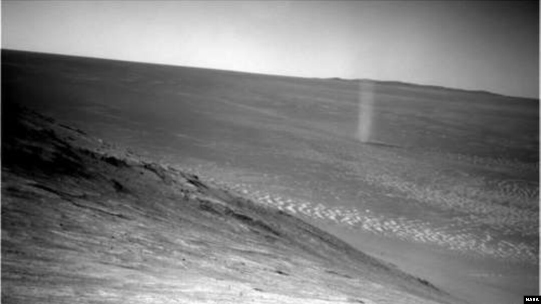 A dust devil is seen swirling across the Martian surface in this photo snapped by the Mars Opportunity rover.