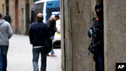 FILE - Police officers in Spain's Catalonia region take positions during an arrest operation, in Barcelona, Oct. 29, 2018.