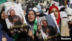 FILE - Protesters from the Islamic Action Front, carry pictures of the deputy overall leader of Jordanian Muslim Brotherhood Zaki Bani Rsheid during a demostration to show their solidarity with Palestinians, in Amman, November 28, 2014. 