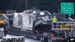 The engine from Monday's deadly Amtrak train crash onto Interstate 5 is transported from the scene, Dec. 20, 2017, in DuPont, Wash.
