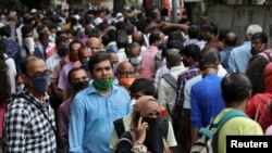 Personas esperan para abordar un autobús durante las horas de mayor tráfico en la ciudad de Mumbai, India, uno de los países con más casos reportados de COVID-19 en este momento.
