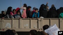 FILE - Women and children displaced by fighting between Iraqi forces and Islamic state militants stand inside a truck as they wait to be taken out of Mosul, Iraq, Nov. 18, 2016. Iraqi authorities have moved hundreds of foreign wives and children of suspected Islamic State militants from a detention center in northern Iraq to Baghdad.