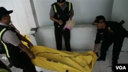Polisi membawa jenazah korban kebakaran ferry ke rumah sakit di Surabaya, Jawa Timur (28/9).