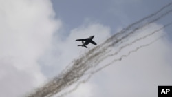 FILE - A Nigerian air force fighter jet flies behind trails of smoke above Kwenev airbase, on the outskirts of Makurdi, Nigeria, April. 21, 2017. A similar jet was shot down Monday by an armed criminal gang.