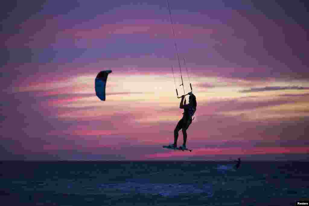 A man surfs with his kite in the Mediterranean sea at the southern Israeli city of Ashkelon, during the vacation of the Jewish holiday of Passover.