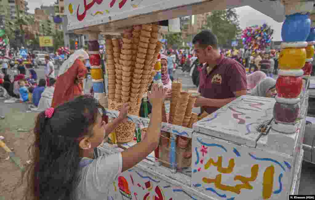 With the fast now over, a girl eagerly waits for an ice cream cone. 