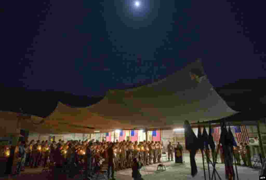 Soldiers with the U.S. Army's 25th Infantry Division, 3rd Brigade Combat Team, 2nd Battalion 27th Infantry Regiment based in Schofield Barracks, Hawaii, hold a ceremony under a full moon to commemorate the tenth anniversary of the 9/11 attacks and soldier