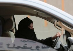 FILE - A woman drives a car on a highway in Riyadh, Saudi Arabia, as part of a campaign to defy Saudi Arabia's ban on women driving, March 29, 2014.