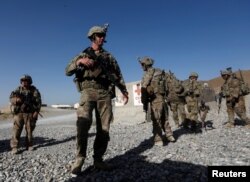FILE - U.S. troops wait for their helicopter flight at an Afghan National Army (ANA) base in Logar province, Afghanistan, Aug. 7, 2018.