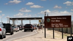 FILE - This Sept. 9, 2014 file photo shows cars wait to enter Fort Bliss in El Paso, Texas. 