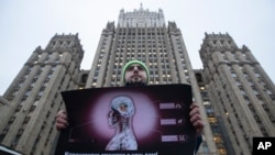 Andrei Nikolayev, an activist of the Green Alternative party, protests outside the Foreign Ministry headquarters building, to call on officials to do more to prevent the spread of the coronavirus, in Moscow, Jan. 24, 2020.