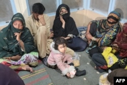 Freed train passengers gather at the Mach railway station after Pakistani security forces freed nearly 80 passengers after a security operation against armed militants who ambushed the train in Mach, southwestern Balochistan province, on March 11, 2025.