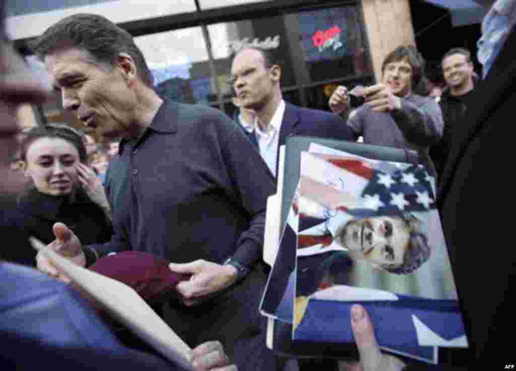 Republican presidential candidate, Texas Gov. Rick Perry signs autographs after a campaign stop at the Blue Strawberry Coffee Company, Thursday, Dec. 29, 2011, in Cedar Rapids, Iowa. (AP Photo/Charlie Neibergall)